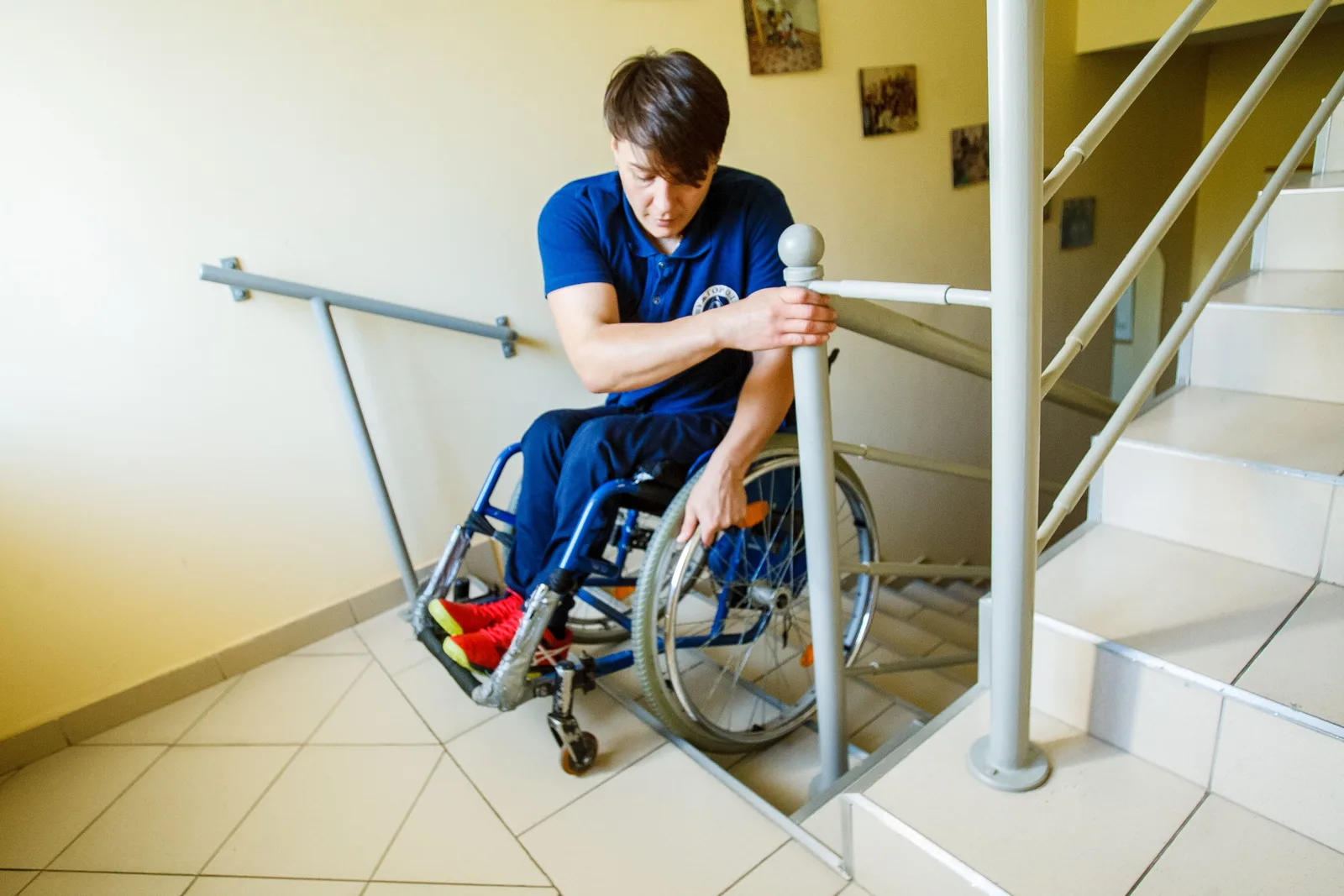 A man in a wheelchair using a staircase railing for support indoors. Home mobility equipment under review: the good, the weak and the verdict